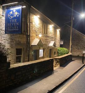 a building with a sign for the seven stars at night at The Seven Stars in Timsbury