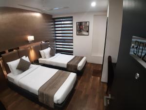 a hotel room with two beds and a window at The Opus Kolkata - A Boutique Hotel in Kolkata