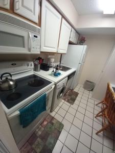a small kitchen with a stove and a sink at #1BR Condo 15Mins To Disney, Universal, Old Town & Parks in Kissimmee