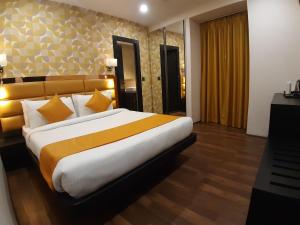 a bedroom with a large bed with yellow and white pillows at The Opus Kolkata - A Boutique Hotel in Kolkata +32 photos