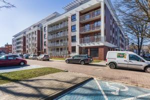 ein weißer Lieferwagen, der vor einem Gebäude geparkt ist in der Unterkunft TS New Town Apartments in Stettin