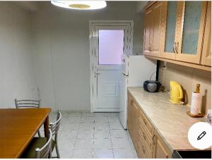 a kitchen with a table and a white refrigerator at Dina’s house in Argostoli