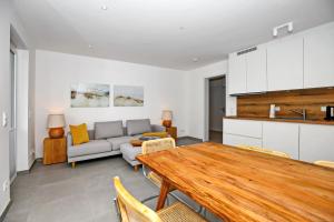 ein Wohnzimmer mit einem Tisch und einem Sofa in der Unterkunft Strandresidenz Dünenperle Wohnung 9 in Kühlungsborn