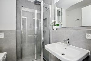 a bathroom with a shower and a white sink at Strandresidenz Dünenperle Wohnung 9 in Kühlungsborn