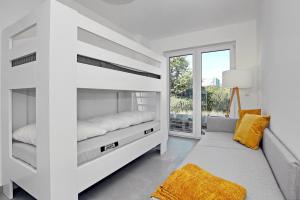 a white bedroom with a bunk bed and a window at Strandresidenz Dünenperle Wohnung 9 in Kühlungsborn