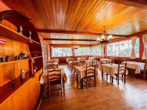 un comedor con mesas y sillas en en Hotel Ascona, en Campos do Jordão