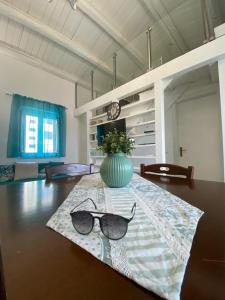 a pair of glasses sitting on a table with a vase at Marisa’s House in Cefalù