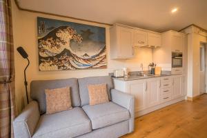 a living room with a couch and a kitchen at The Hideaway in Lochinver