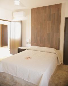 1 dormitorio con 1 cama blanca grande en una habitación en Hotel Conquistador, en Mazatlán