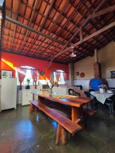 uma sala de jantar com uma mesa e uma cozinha em Quinta da Bela Vista em Caeté