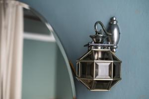 a lantern hanging on a wall next to a mirror at La Didì Maison in Bologna