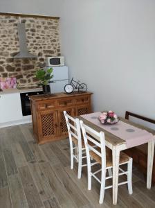 cocina con mesa y sillas en una habitación en Les petits gites, en Ernée