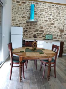 cocina con mesa de madera y sillas en Les petits gites, en Ernée