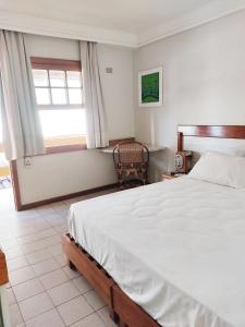 een slaapkamer met een groot bed en een raam bij Pousada Pier do Pontal in Ilhéus
