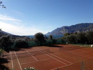 een tennisbaan met bergen op de achtergrond bij RESIDENCE KORMORANO MALCESINE in Malcesine