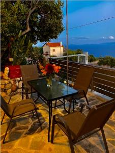 a table with chairs and a vase of flowers on a patio at Dina’s house 2 in Argostoli