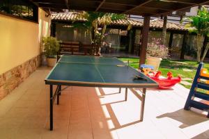 a ping pong table sitting on a patio with a table at Geriba Beach apart hotel apt504 in Búzios