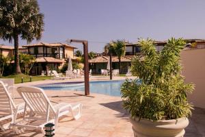 a resort with a pool and chairs and a resort at Geriba Beach apart hotel apt504 in Búzios