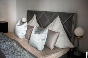 - un lit avec un bouquet d'oreillers dans l'établissement Exclusive calm and designer flat - Yael's apartments - Charlottenburg by Arbio, à Berlin