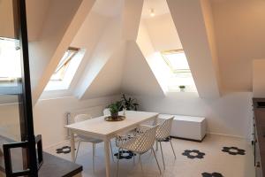 a dining room with a white table and chairs at Urban Oasis Apartments with Parking in Bucharest