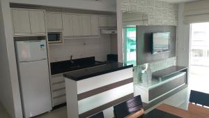 een keuken met een witte koelkast en een aanrecht bij Cozumel in Bombinhas