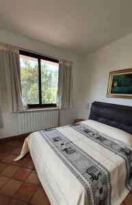 a bedroom with a large bed and a window at Villa Canu in Alghero