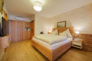 1 dormitorio con 1 cama grande y TV en ARKADENHOF zur Puszta GRAF en Illmitz
