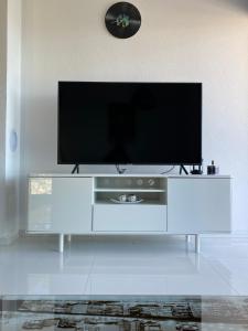 a white entertainment center with a flat screen tv on it at Villa Sun&Sea in Komarna