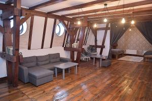 a living room with a couch and wooden floors at Apartament na Piernikarskiej in Toruń