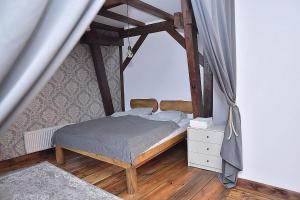 a bedroom with a bed and a wooden floor at Apartament na Piernikarskiej in Toruń