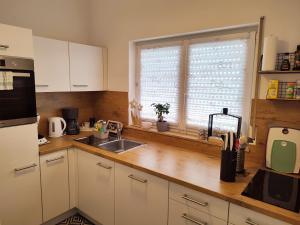 a kitchen with white cabinets and a sink and a window at Ferienwohnung Susanna in Friedrichshafen