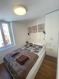 1 dormitorio con 1 cama con manta marrón en Jolly -Center Bright Apartment at Tartini Square, en Piran