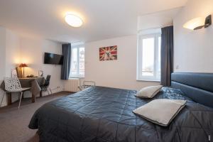 - une chambre avec un grand lit et un canapé bleu dans l'établissement Relais Lorraine Alsace Pere & Fils, à Raon-lʼÉtape