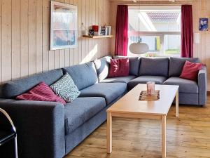 オッテルンドルフにある6 person holiday home in Otterndorfのリビングルーム(青いソファ、テーブル付)