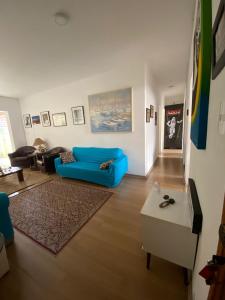 a living room with a blue couch and a table at Acomodações Hamzo in São Paulo