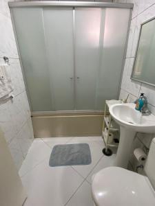 a bathroom with a shower and a sink and a toilet at Acomodações Hamzo in São Paulo