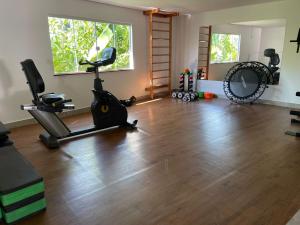 a gym with exercise equipment in a room with a wooden floor at Pousada Videira de Teresópolis in Teresópolis
