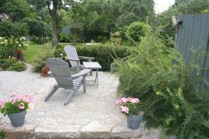 two chairs and a table in a garden with flowers at Matrix Garden Apartments in Tallinn