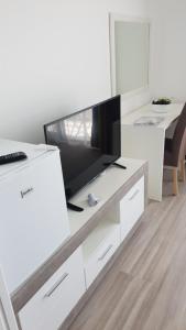 a living room with a tv on a white entertainment center at Hotel Svarog in Bečići