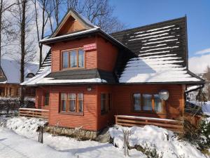 a wooden house is covered in snow at Willa Pod Jesionami in Zakopane