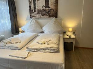 a bed with white sheets and towels on it at Eifelerhof hotel Monschau in Monschau