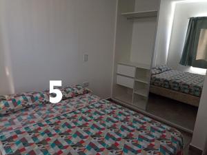 Un dormitorio con una cama con el número. en Duplex Houssay. en Aldea Camarero