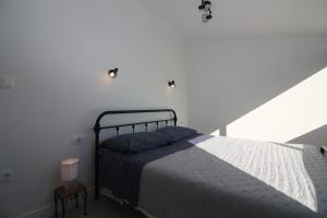 a bed in a white room with a white wall at Apartments Fortunato in Zablaće