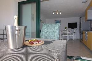 a table with a bottle of wine and a plate of food at Apartments Fortunato in Zablaće