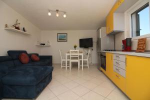 a kitchen and a living room with a couch and a table at Apartments Fortunato in Zablaće