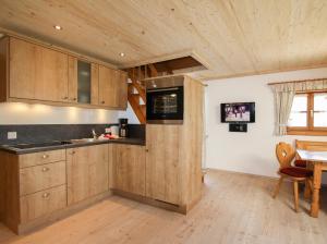 cocina con armarios de madera, mesa y ventana en Weissenhof - Chiemgau Karte, en Inzell