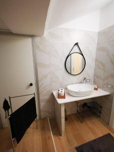 W łazience znajduje się umywalka i lustro. w obiekcie Pvteoli Suite w mieście Pozzuoli