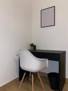 białe krzesło siedzące przed biurkiem w obiekcie Pvteoli Suite w mieście Pozzuoli