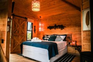 una camera con un letto in una cabina di legno di Casa na Árvore Morada dos Vagalumes a Farroupilha