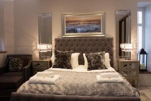 um quarto com uma cama grande e almofadas em Liberty at Utopia Penthouse by MGroupSA em Swansea